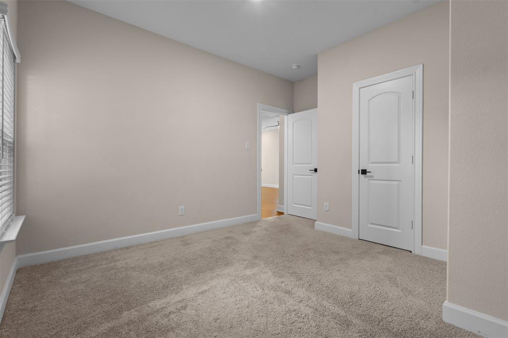 Neutral wall color, carpeted flooring, white two-panel interior doors, and matte black door hardware