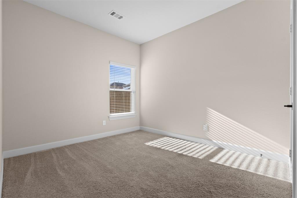 Neutral-toned interior space featuring neutral wall paint, carpeted flooring, and a single-pane window with installed blinds