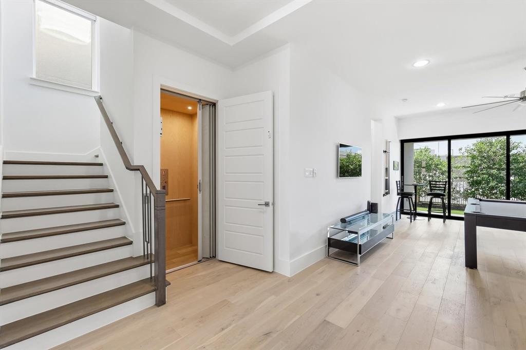 Interior featuring a built-in residential elevator, wood-finish flooring, recessed lighting, and sliding glass doors Interior featuring a built-in residential elevator, wood-finish flooring, recessed lighting, and sliding glass doors