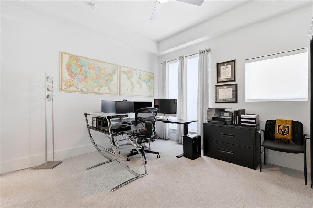 Room with neutral wall-to-wall carpeting, high ceilings, multiple tall windows, and a ceiling-mounted light fixture Room with neutral wall-to-wall carpeting, high ceilings, multiple tall windows, and a ceiling-mounted light fixture
