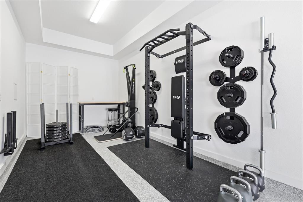 Dedicated room featuring an epoxy-coated concrete floor, recessed tray ceiling, and linear fluorescent lighting
