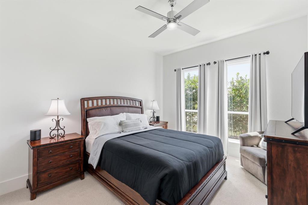 Neutral wall coloring, ceiling-mounted fan with integrated light, and two large vertical windows