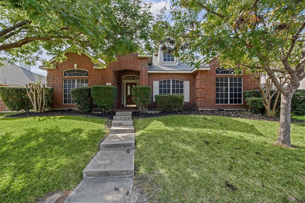 Brick exterior featuring arched window detailing, a recessed covered entryway, and multi-pane windows Brick exterior featuring arched window detailing, a recessed covered entryway, and multi-pane windows