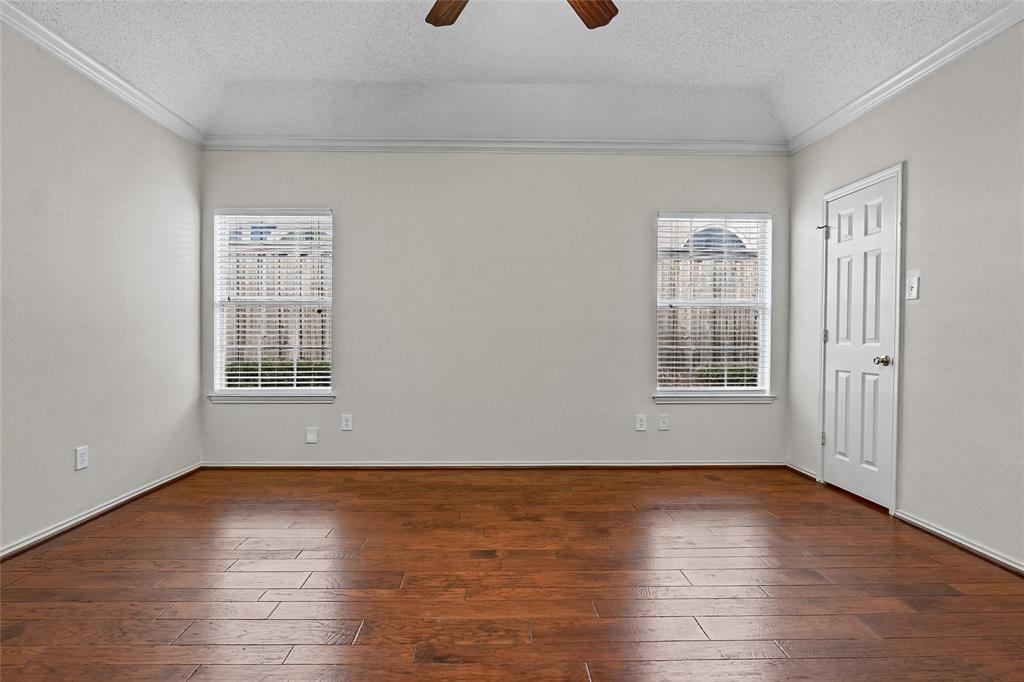 Tray ceiling, wood-finish flooring, two dual-pane windows with horizontal blinds, and a six-panel door
