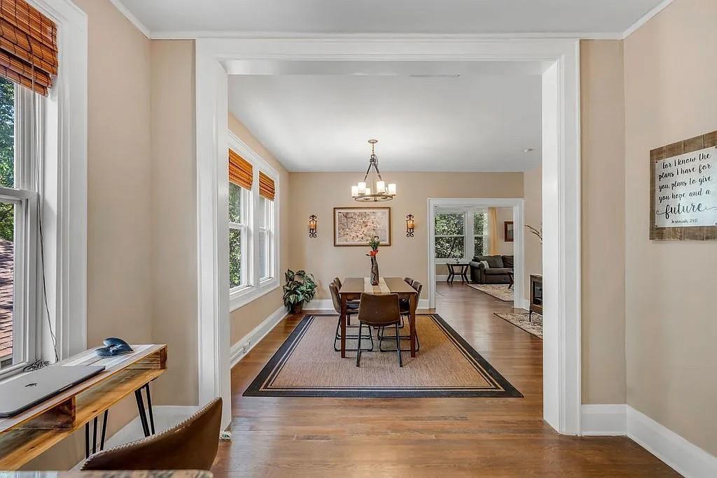 Hardwood flooring, multi-pane windows with integrated casings, crown molding, and polished nickel multi-arm chandelier lighting Hardwood flooring, multi-pane windows with integrated casings, crown molding, and polished nickel multi-arm chandelier lighting