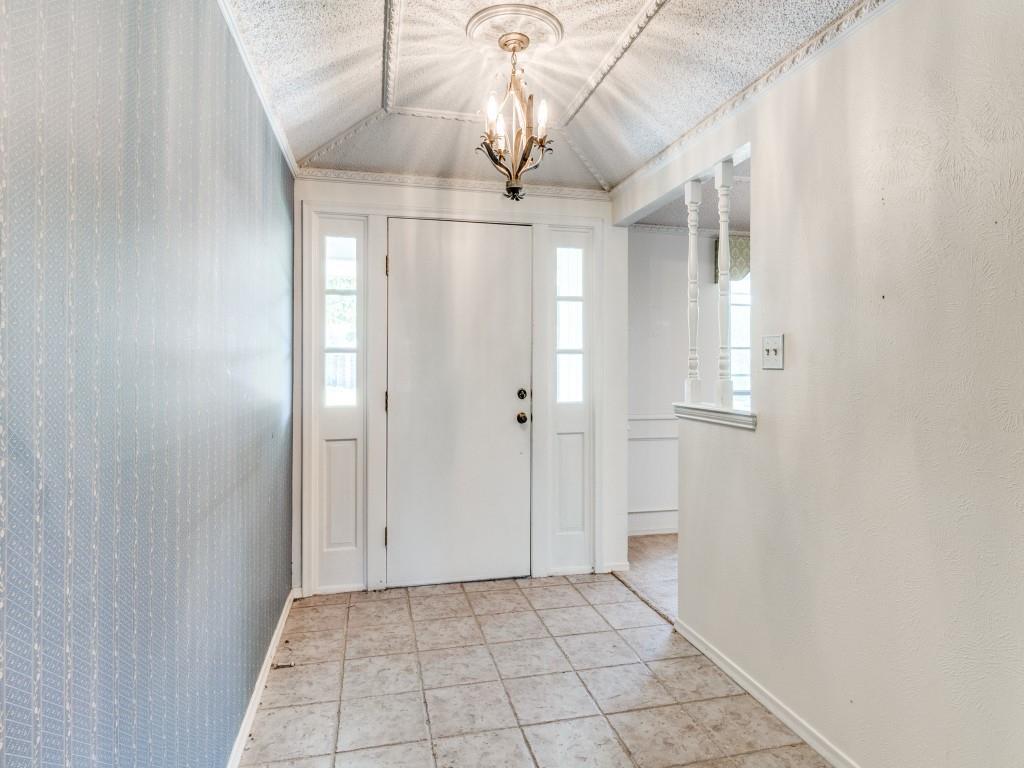 Foyer with vaulted ceiling, a chandelier, and baseboards