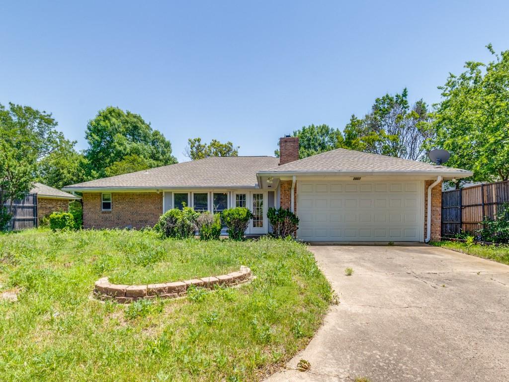 Ranch-style home with fence, a chimney, brick siding, an attached garage, and driveway