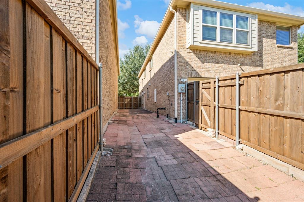 Brick exterior siding, paver patio, and wood privacy fencing