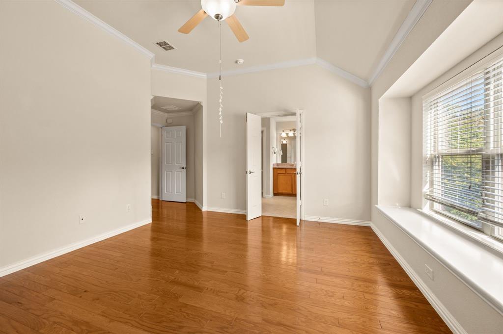 Vaulted ceilings, wood-finish flooring, built-in window seat, and ceiling fan fixture