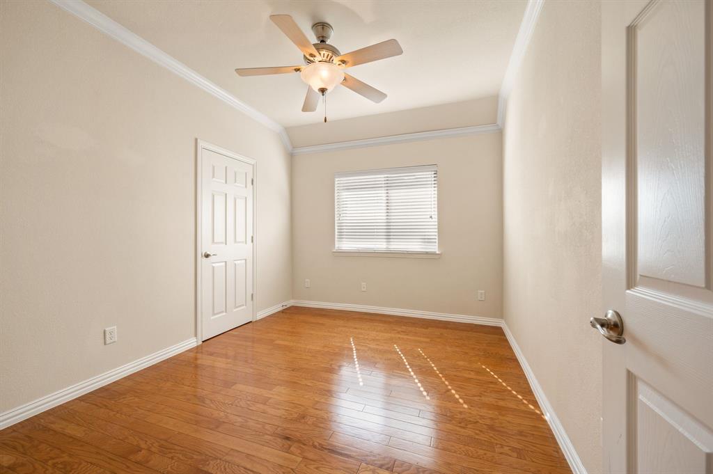 Room featuring wood-finish flooring, vaulted ceilings, crown molding, a central ceiling fan with integrated lighting, and a window with horizontal blinds