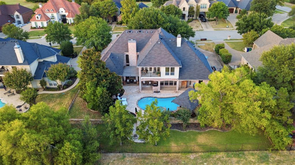 Expansive rear exterior featuring a swimming pool, covered patio, second-story balcony, and mature trees. This home backs up to the green belt for privacy. The custom details enhances the view as the sun sets around it. Expansive rear exterior featuring a swimming pool, covered patio, second-story balcony, and mature trees. This home backs up to the green belt for privacy. The custom details enhances the view as the sun sets around it.