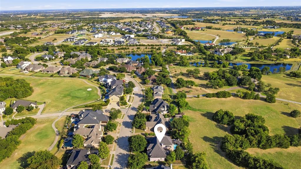 Aerial perspective of a residential neighborhood featuring established homes, mature trees, and a street network