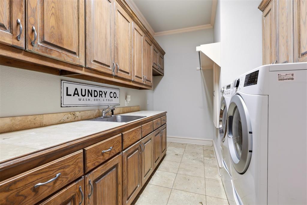 Wood-finish cabinetry, tile countertops with integrated sink, tile flooring, and integrated clothes hanging rack and room for Freezer or Refrigerator