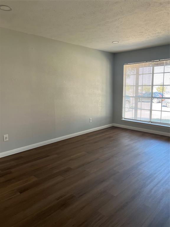 Room featuring wood-finish flooring, recessed lighting, and a multi-pane window with blinds Room featuring wood-finish flooring, recessed lighting, and a multi-pane window with blinds