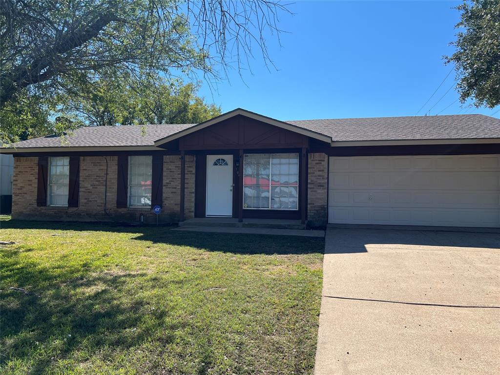 Single-story exterior featuring a brick facade, gabled entryway, attached two-car garage, concrete driveway, and mature landscaping Single-story exterior featuring a brick facade, gabled entryway, attached two-car garage, concrete driveway, and mature landscaping