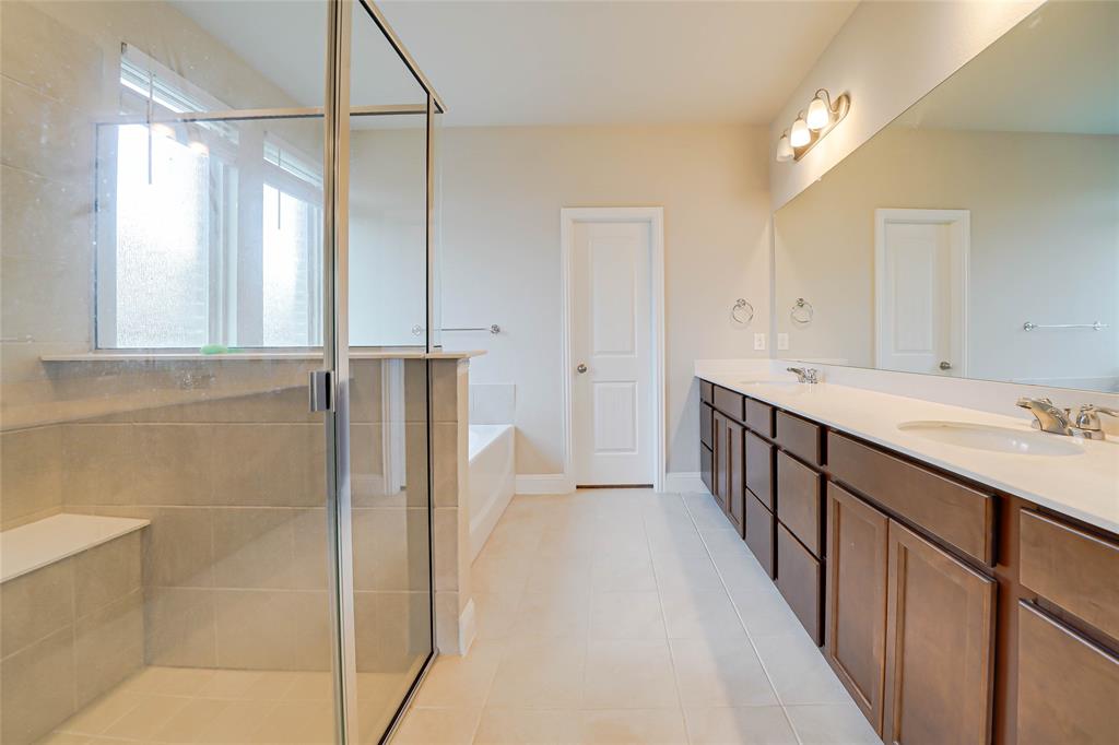 Full bath with a stall shower, a bath, double vanity, and light tile patterned floors