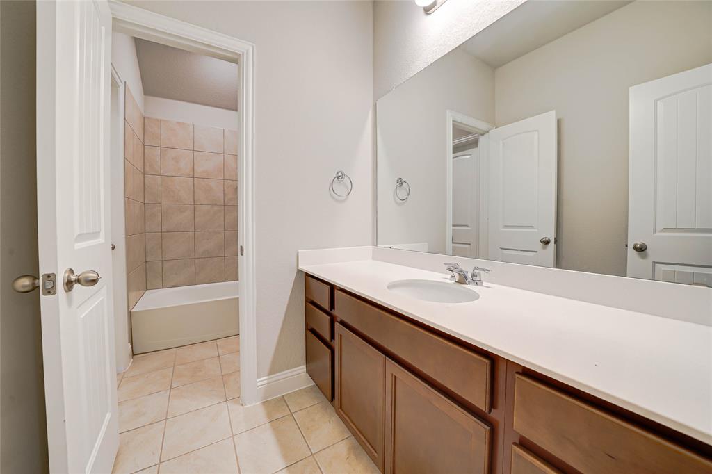 Bathroom featuring vanity, light tile patterned floors, and shower / bathtub combination