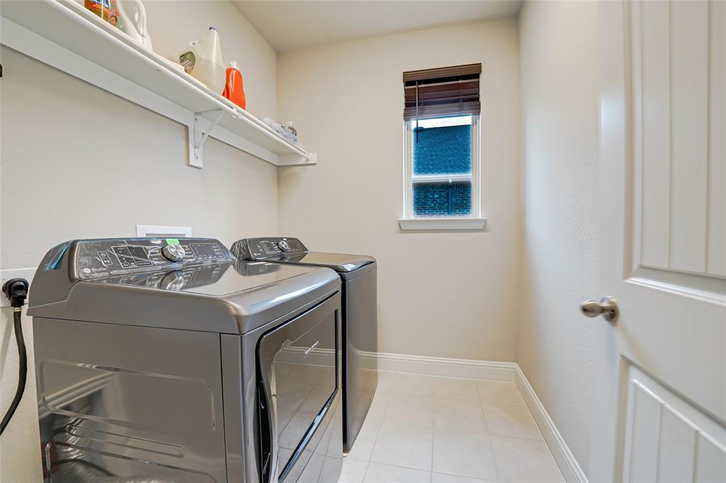 Laundry area featuring washing machine and dryer and light tile patterned flooring