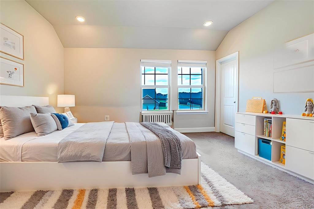 Bedroom featuring light colored carpet, lofted ceiling, recessed lighting, and radiator