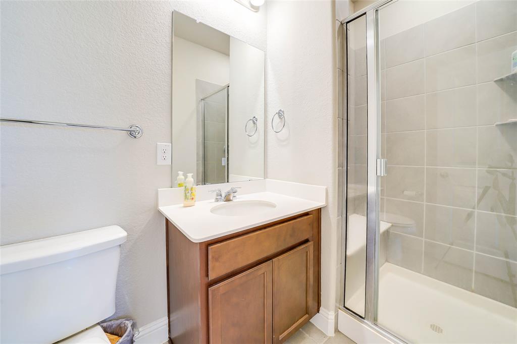 Full bathroom with vanity, a shower stall, and a textured wall