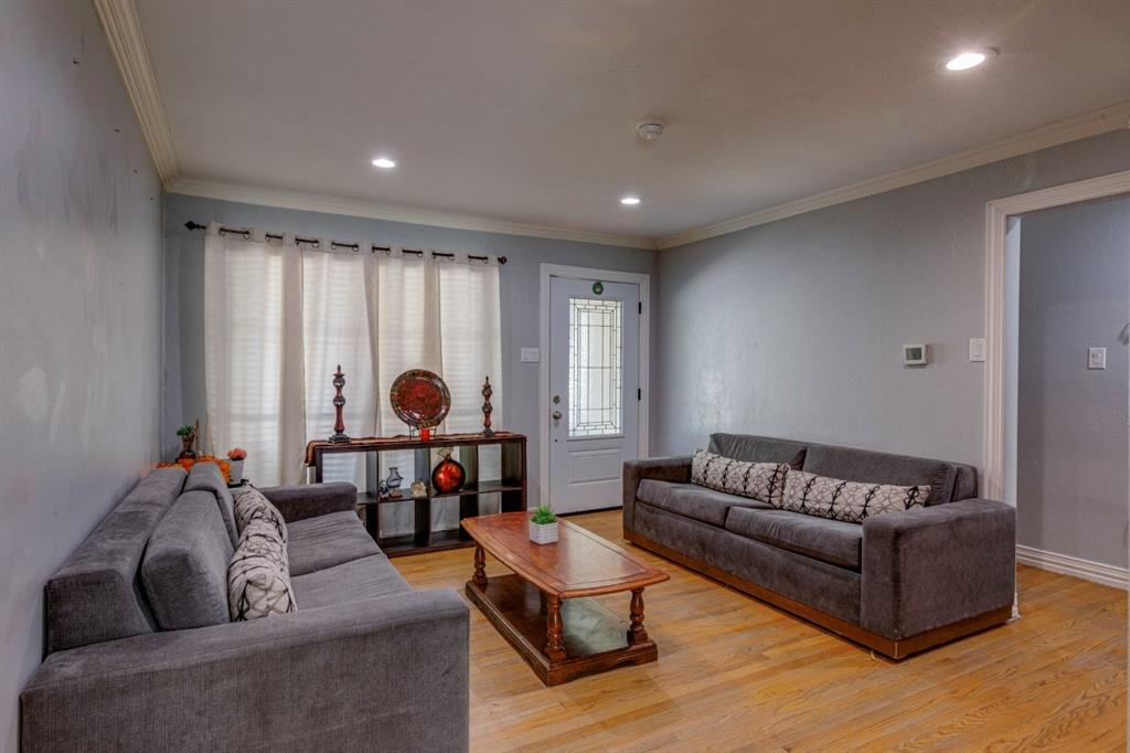 Living space featuring wood-finish flooring, crown molding, recessed lighting, and a front entry door with a decorative glass insert