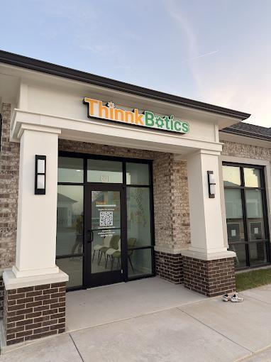 Exterior facade featuring masonry brickwork, a covered entryway with structural columns, and large-format glass storefront windows with black framing