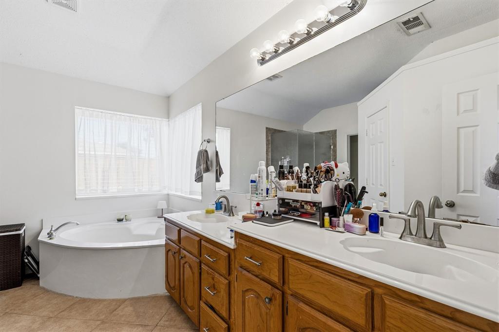 Primary bath features dual sinks, garden tub