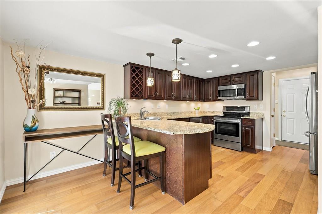 Kitchen featuring dark Kraftmaid cabinets, granite counter tops, and stainless steel appliances. Kitchen featuring dark Kraftmaid cabinets, granite counter tops, and stainless steel appliances.