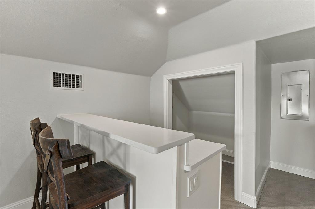 Built-in breakfast bar featuring a solid-surface countertop and recessed ceiling lighting