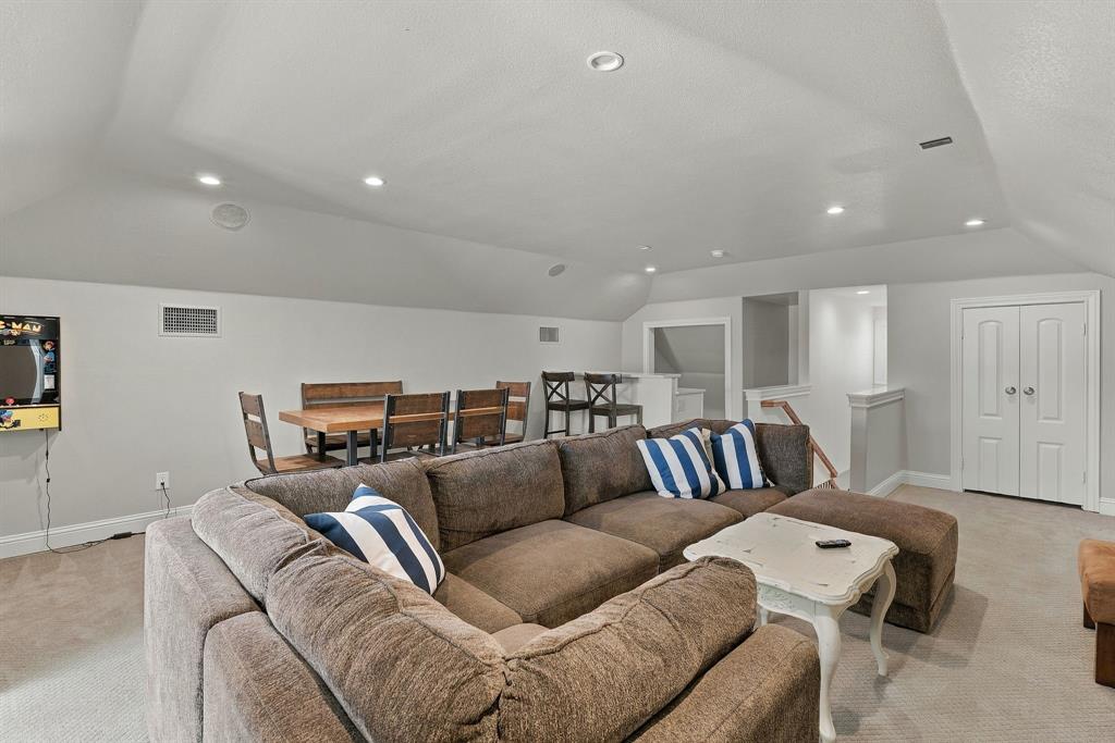 Expansive room featuring vaulted ceilings, recessed lighting, neutral carpeting, and white dual-panel doors