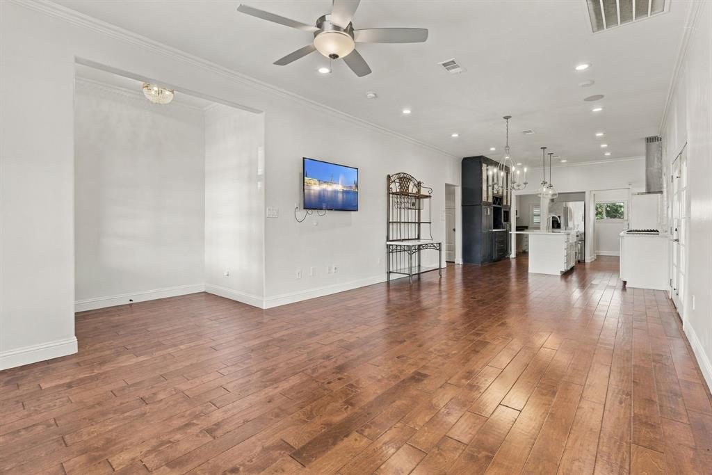 Open-concept interior featuring wood-finish flooring, recessed lighting, ceiling fan, and crown molding