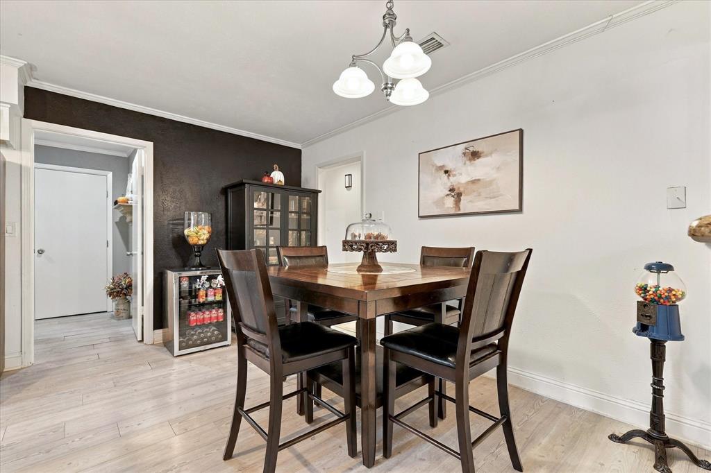 Interior space featuring wood-finish flooring, a three-light chandelier, and a black accent wall