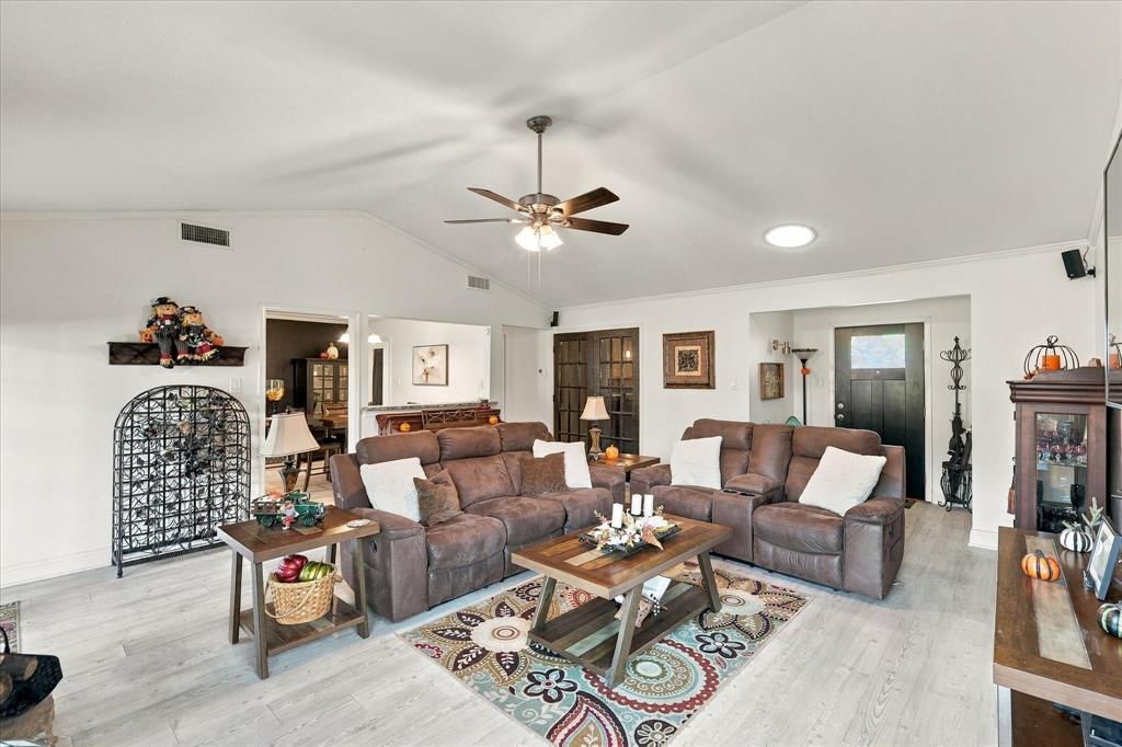 Vaulted ceilings, wood-finish flooring, ceiling fan with integrated lighting, skylight, and glass-paneled interior French doors