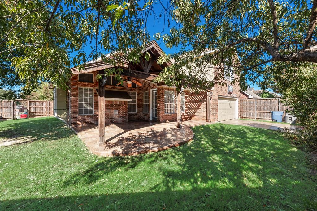 Brick exterior featuring a covered patio, exposed timber framing, dual-pane windows, and attached garage