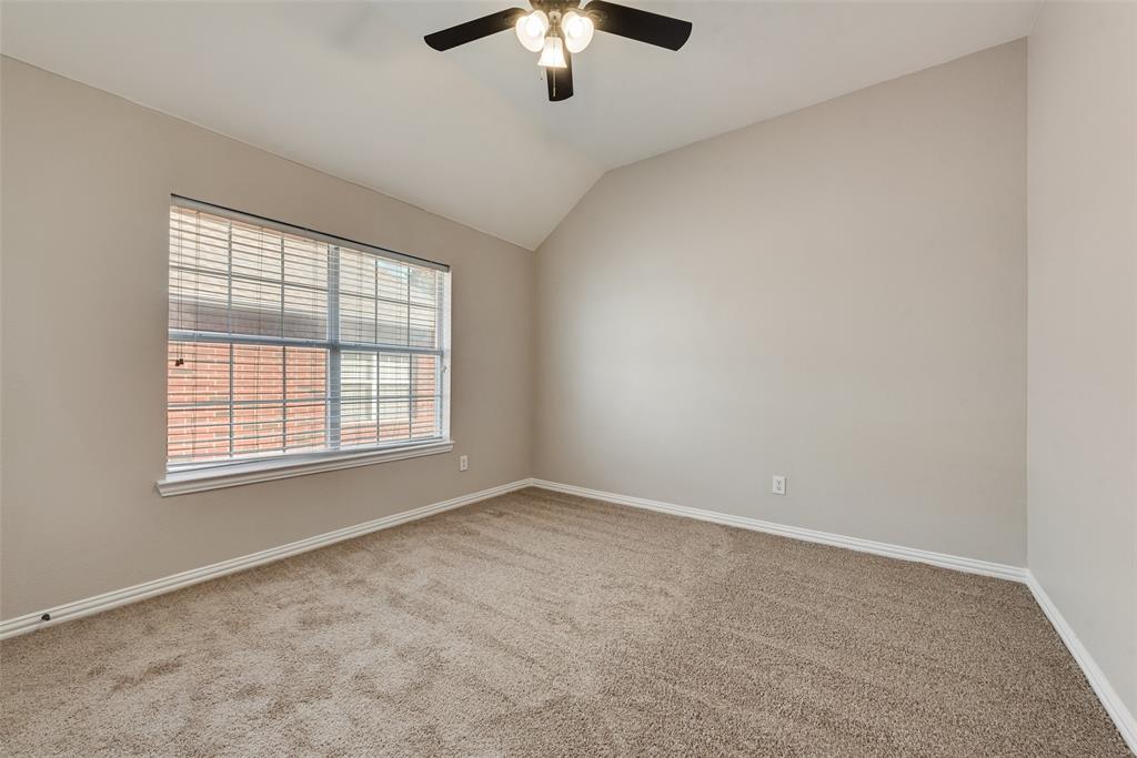Vaulted ceiling, neutral wall tones, wall-to-wall carpeting, multi-pane window, and a central ceiling fan with an integrated light fixture