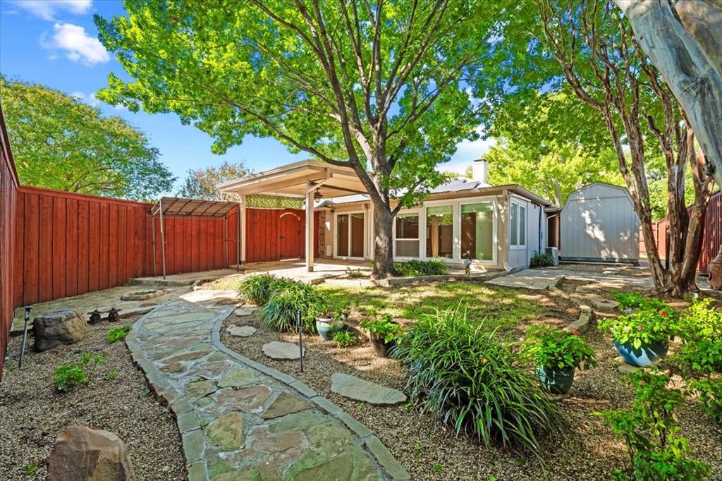 Extensive flagstone walking path - view of storage building - lovely shade trees 8 ft board on board cedar fencesteel posts on driveway side