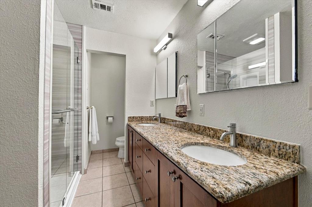 Two sinks, granite counter tops - custom cabinets - double glass mirrors with hidden medicine cabinetsCommode behind the wall with more cabinets