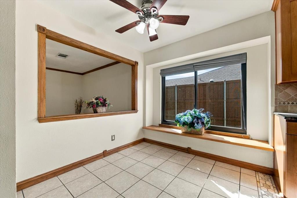 Window seat in breakfast area and opening to the game room - ceiling fan  - views to side yard with 8ft cedar fence