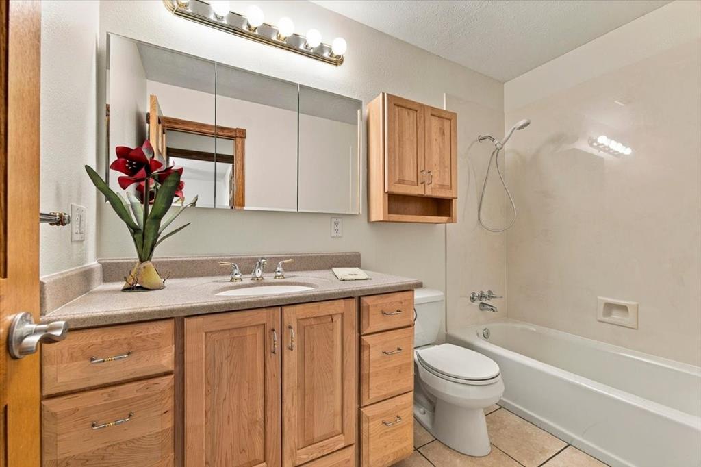 Hall bath for the 2 front bedrooms - custom cabinets - glass mirrors - no grout lines in tub-shower