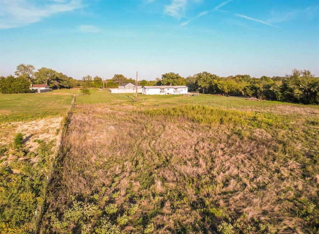 Expansive acreage featuring open fields, peripheral mature trees, and wire perimeter fencing