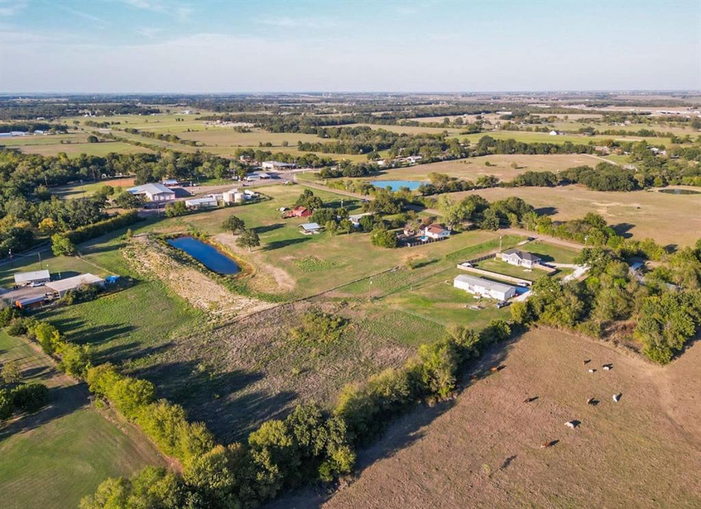 Expansive rural acreage featuring open pasture land, multiple ponds, and mature tree clusters