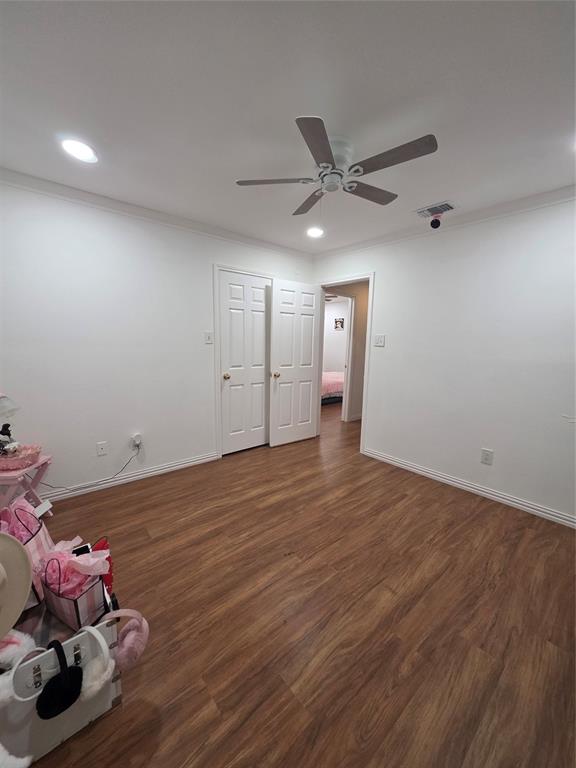 Room featuring wood-finish flooring, recessed lighting, a ceiling fan, and white paneled doors