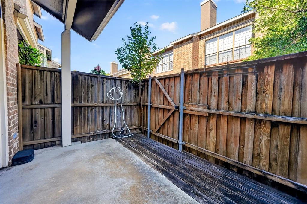 Private courtyard featuring a concrete patio, wood-finish decking, and wood privacy fencing