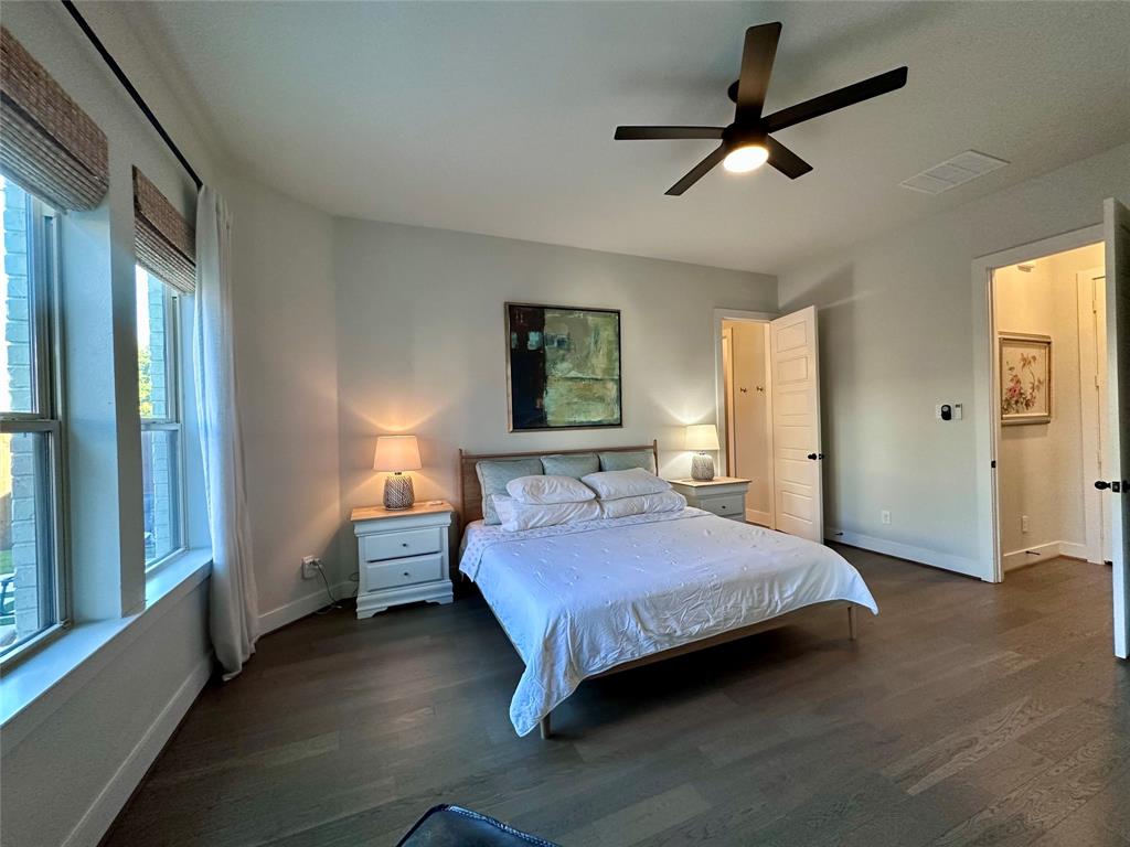 Wood-finish flooring, multi-pane windows, and a matte black ceiling fan with integrated lighting