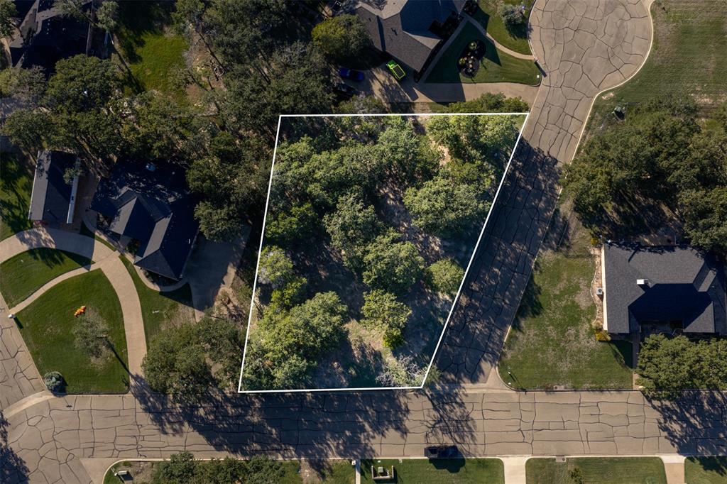 Wooded vacant lot situated on a corner lot of a cul-de-sac road featuring mature tree coverage and established surrounding infrastructure with approximate boundaries outlined