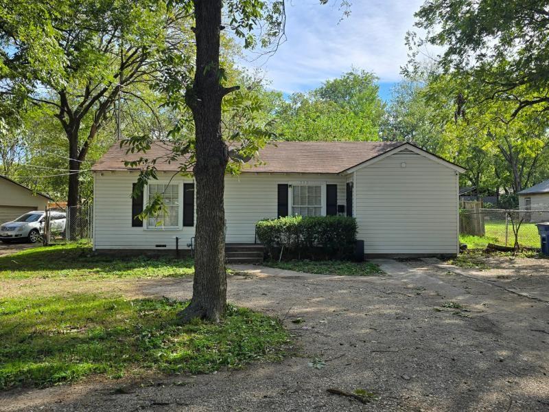 Single-story residence featuring light-colored horizontal siding, a gabled roof, shuttered windows, and a detached garage Single-story residence featuring light-colored horizontal siding, a gabled roof, shuttered windows, and a detached garage