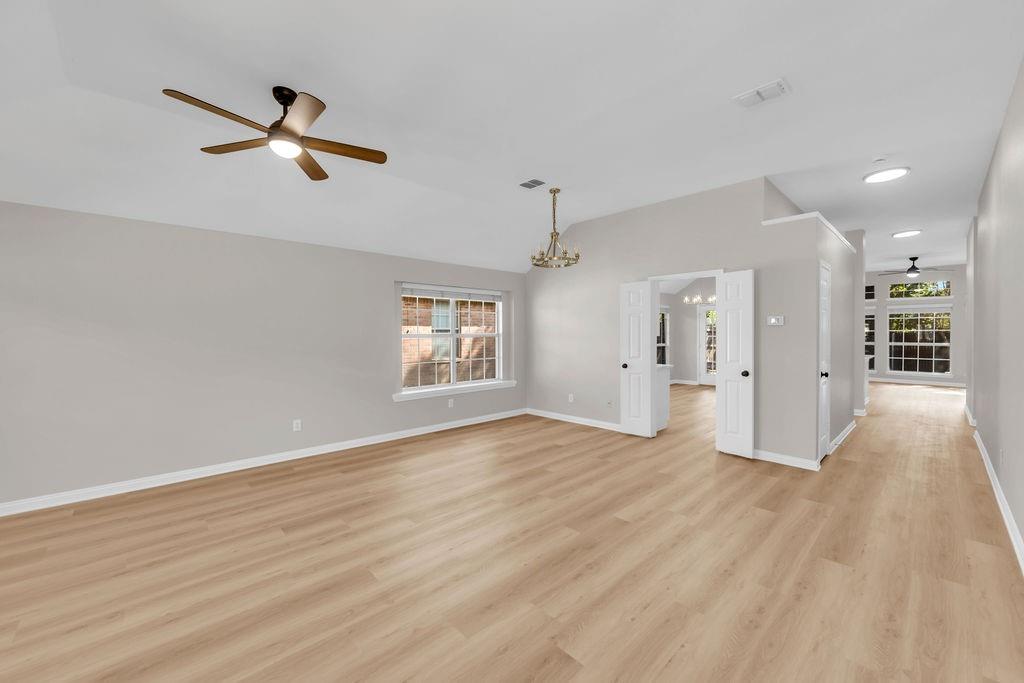 Vaulted ceilings with recessed lighting, wood-finish flooring, multi-pane windows, and dual-swing doors