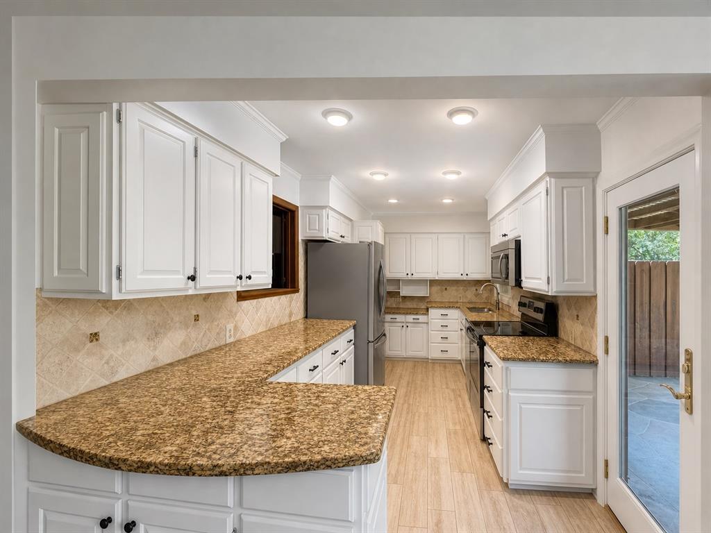 Kitchen featuring white cabinetry, stone-finish countertops, tile backsplash, recessed lighting, and wood-finish flooring