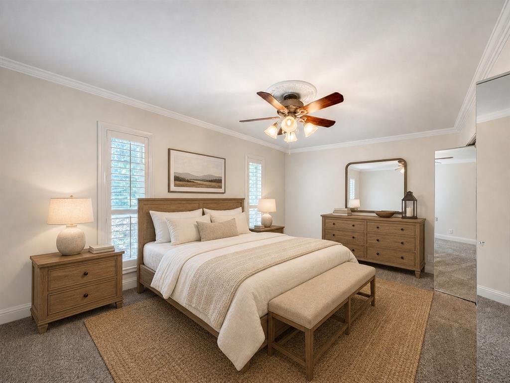 Neutral interior featuring crown molding, wall-to-wall carpeting, windows with interior shutters, and a ceiling fan with integrated lighting