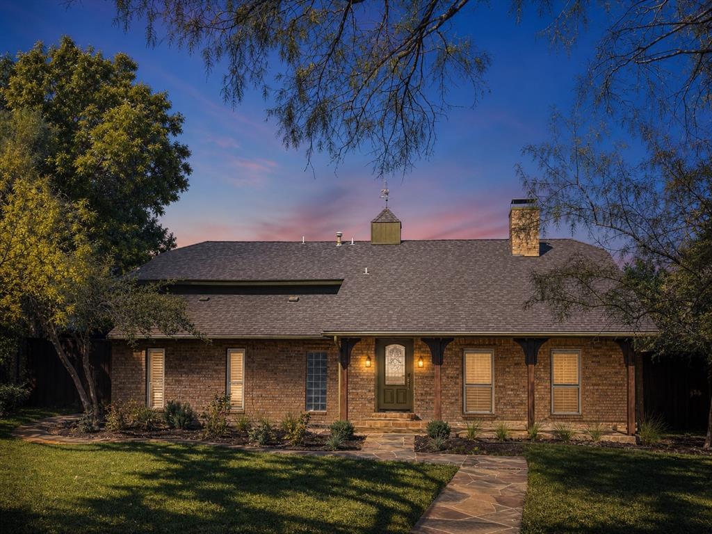 Brick exterior featuring a roof cupola, covered front porch with decorative corbels, stone walkway, and chimney Brick exterior featuring a roof cupola, covered front porch with decorative corbels, stone walkway, and chimney